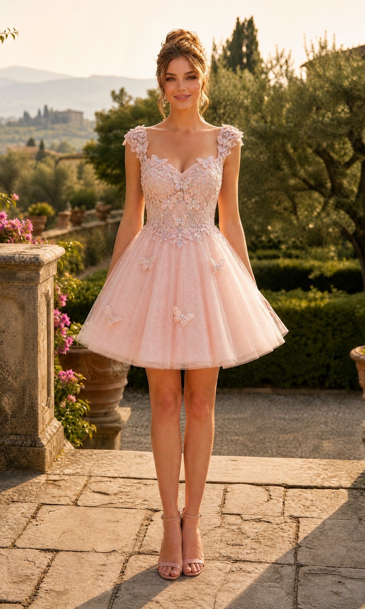 A woman stands outdoors in a garden, wearing the Short Homecoming Dress: Chicas C330 in blush, featuring floral lace appliqués and an A-line tulle skirt, her hair styled up.